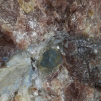 06 Safír, Potůčník, světle modrý zčásti omezený krystal 3 mm zarůstá do bílého diasporu (velmi vzácný minerál) a růžového andaluzitu, foto P. Rozsíval