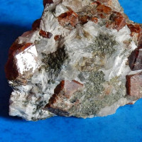 04 Hesonit, Vápenná – Vycpálkův lom, tmavě červené krystaly cca 2 cm v kalcitu (bílý) s šedozeleným diopsidem (zrnitý), foto P. Rozsíval.