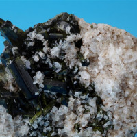 	Epidot, Sobotín, tmavě zelené průsvitné sloupcovité krystaly s bílými krystalky albitu, foto P. Rozsíval