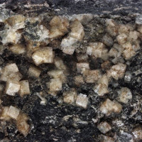Chabazit, Sobotín, bílé krystaly tvaru krychle na puklině amfibolitu, foto J. Král